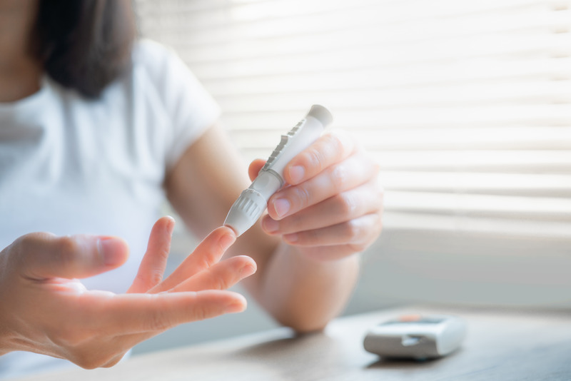 Blood sugar testing Close up woman hands using lancet on finger to check blood sugar level by Glucose meter, Healthcare Medical Check up, Medicine, diabetes, hyperglycemia concept